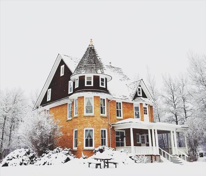 old tudor style home blanketed in snow.