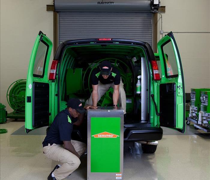 SERVPRO technicians getting inside a van a dehumidifier, drying equipment